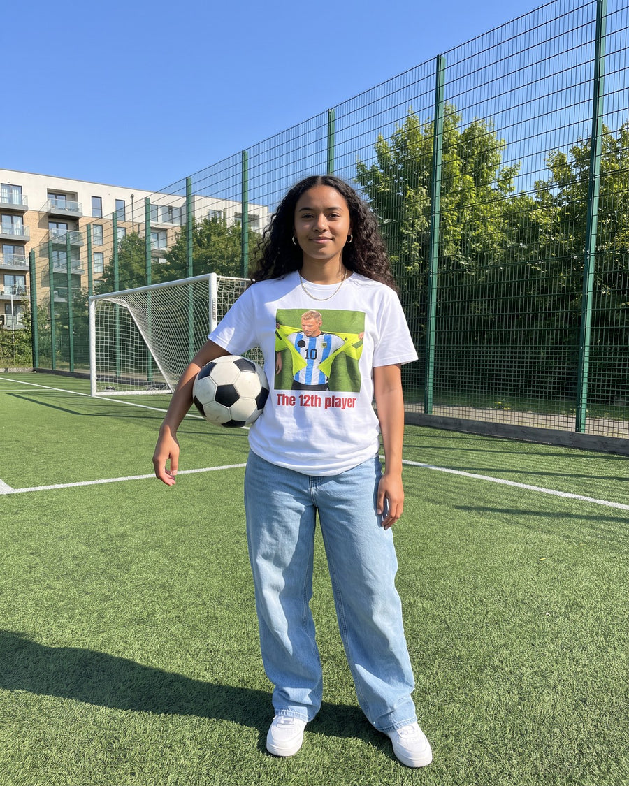 Fan on a football pitch holding a ball, wearing the Le 12ème joueur tee