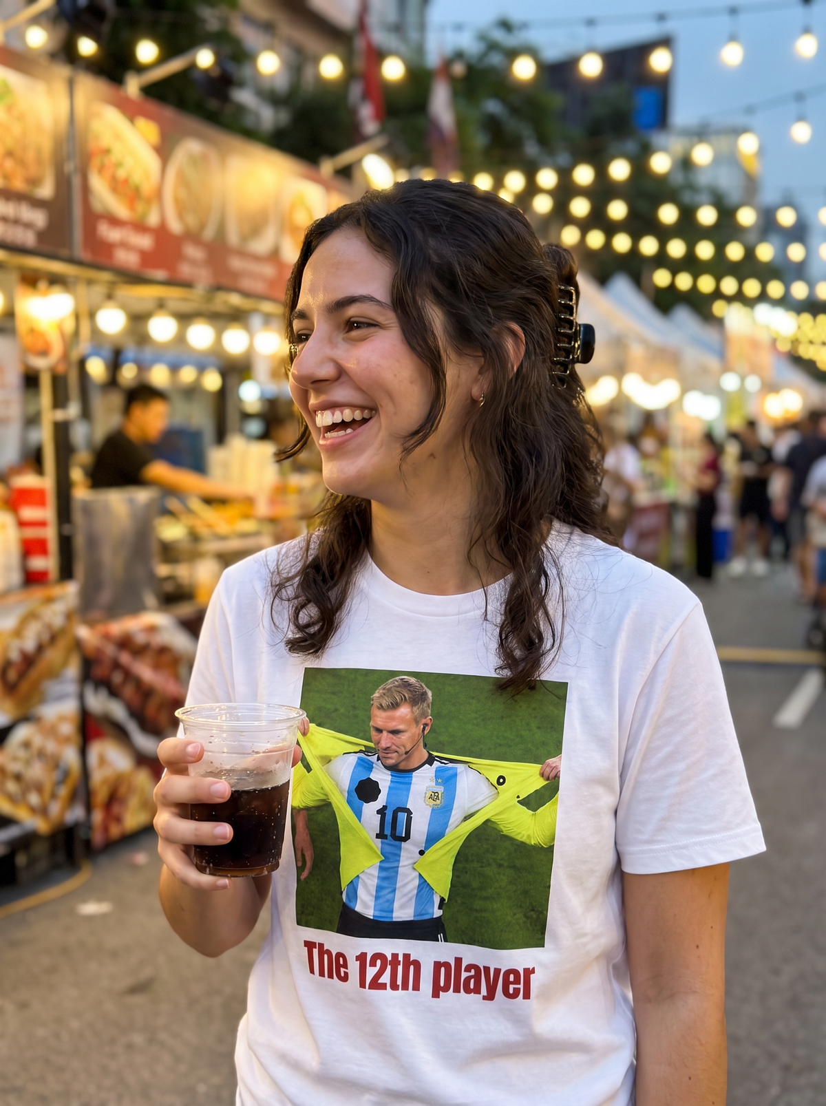 Fan walking down a shopping street in the evening wearing the Le 12ème joueur tee