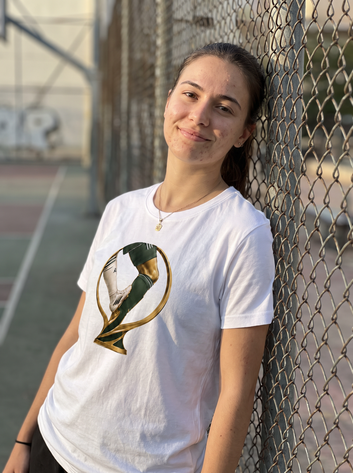 Fan leaning on a basketball court fence wearing the Le nouveau Trophée tee